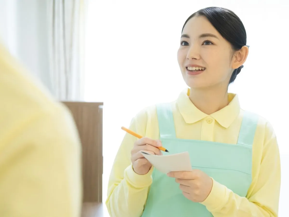 メモを取りながら相手の話に耳を傾けるスタッフ
