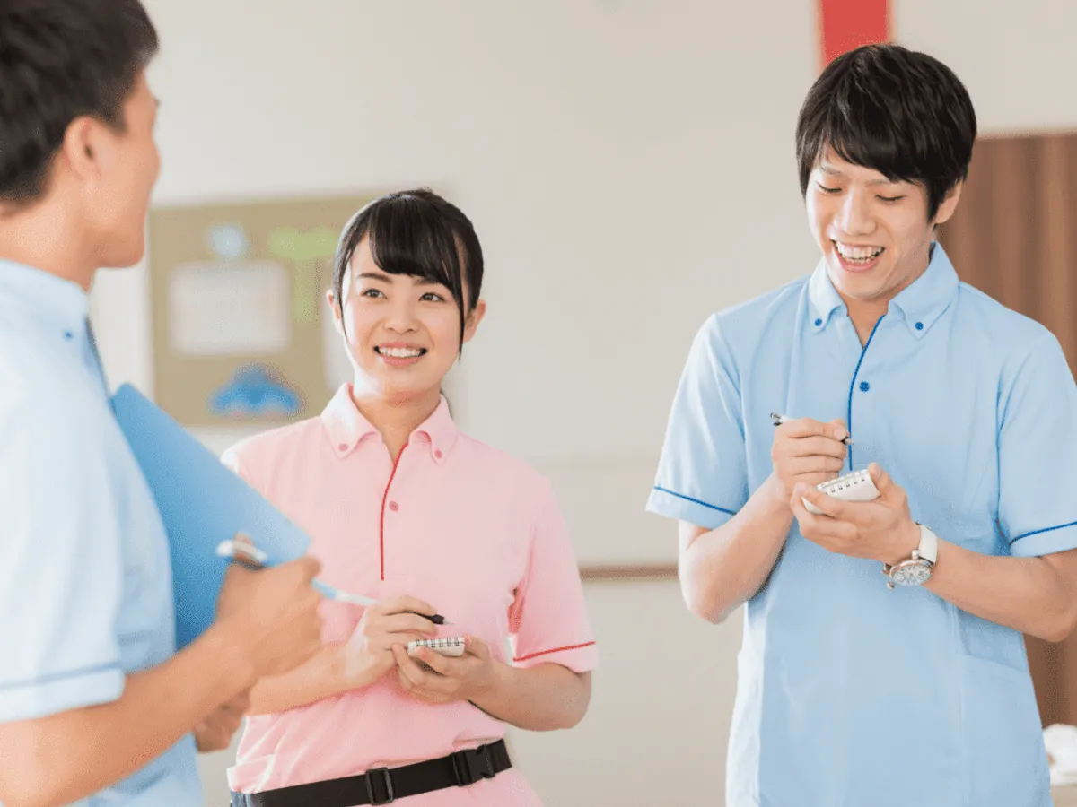 メモを手に打ち合わせをする3人のスタッフ